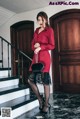 A woman in a red dress is standing on the stairs.