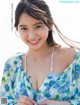 A woman in a blue and white floral dress posing for a picture.