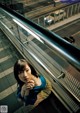 A woman leaning against a railing in a subway station.