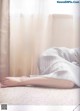 A woman laying on a bed with her feet up on the floor.