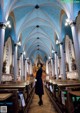 A woman standing in the middle of a church.