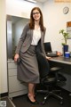 A woman in a business suit standing in an office.